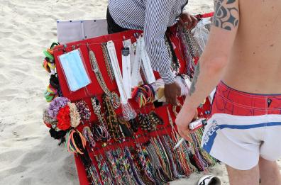 Taranto, i vucumprà si attrezzano contro il Coronavirus e vendono mascherine in spiaggia