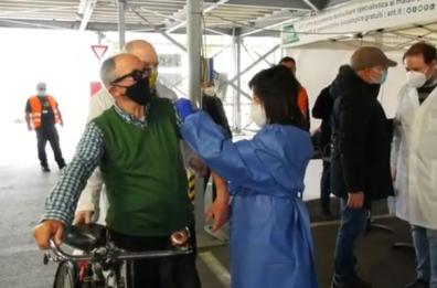 Taranto, applausi per anziano che arriva in bici al drive-through per vaccinarsi