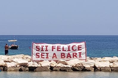 Bari, lo striscione sugli scogli è il miglior spot turistico di sempre: «Sii felice, sei a Bari»