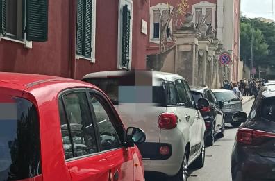 Parcheggia in doppia fila e dice «si faccia gli affari suoi»