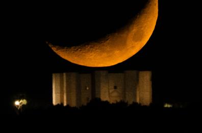 Ecco Castel del Monte sormontato da una gigantesca Luna arancione