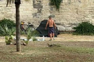 Gli eccessi dei vacanzieri in Salento: a Lecce turista si accampa ai piedi del castello, la foto fa il giro del web