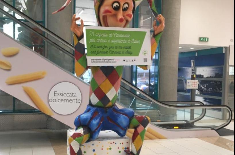 Aeroporto Bari, passeggeri accolti da «Farinella», simbolo del  Carnevale di Putignano