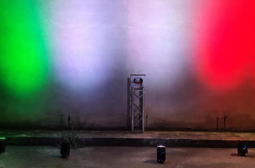 Fase 2, azienda barese di servizi per lo spettacolo protesta con tricolore proiettato sul muro