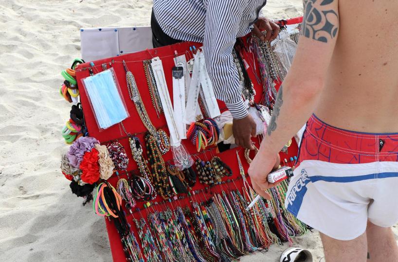 Taranto, i vucumprà si attrezzano contro il Coronavirus e vendono mascherine in spiaggia